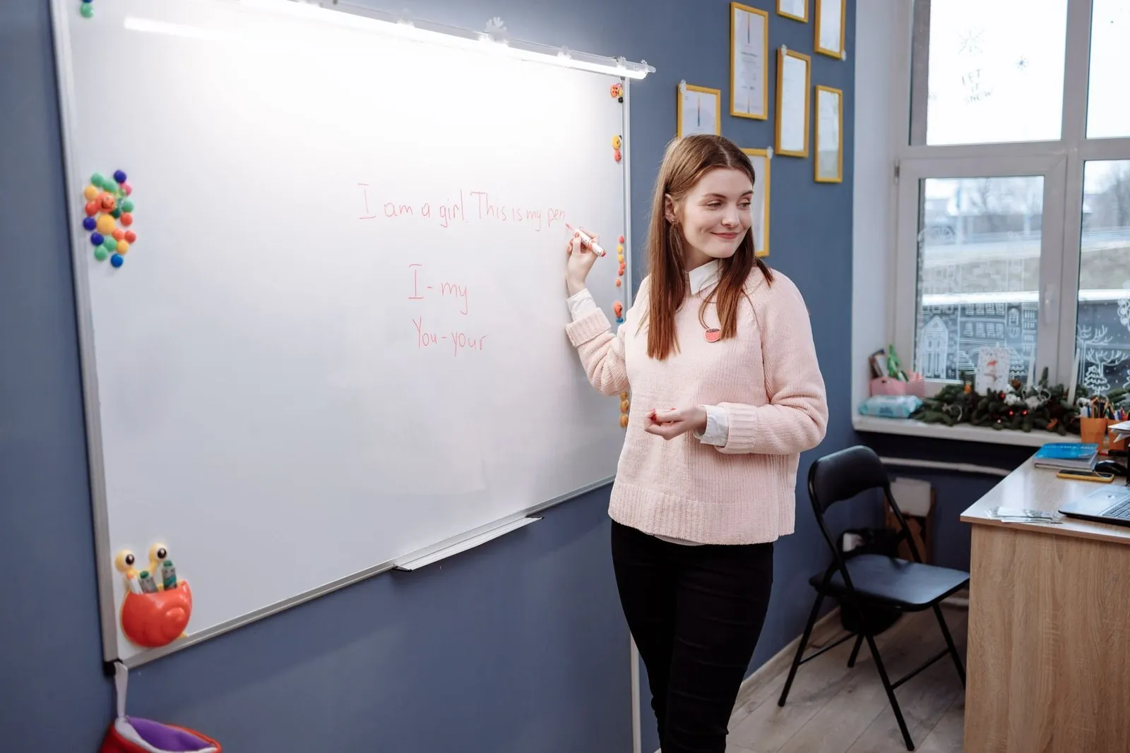 English teacher writing grammar notes on a classroom whiteboard