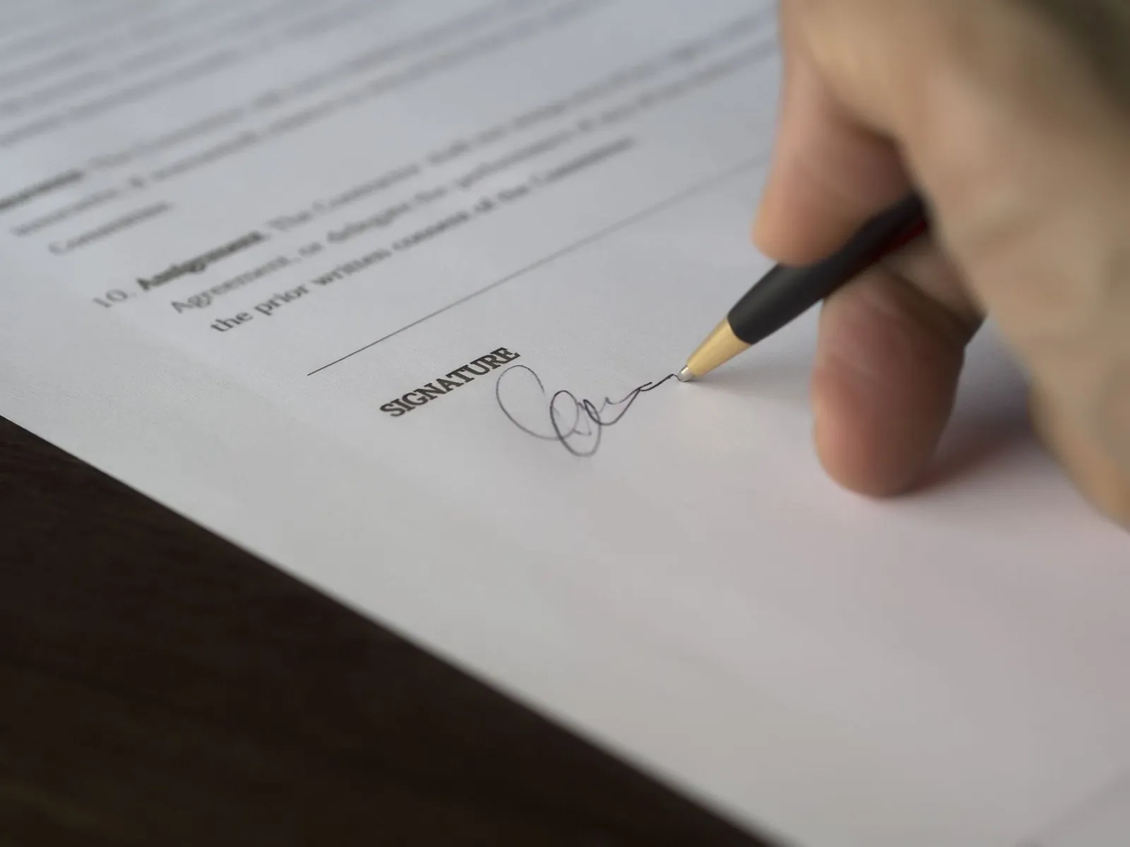 Close-up of a hand signing an employment contract with a pen