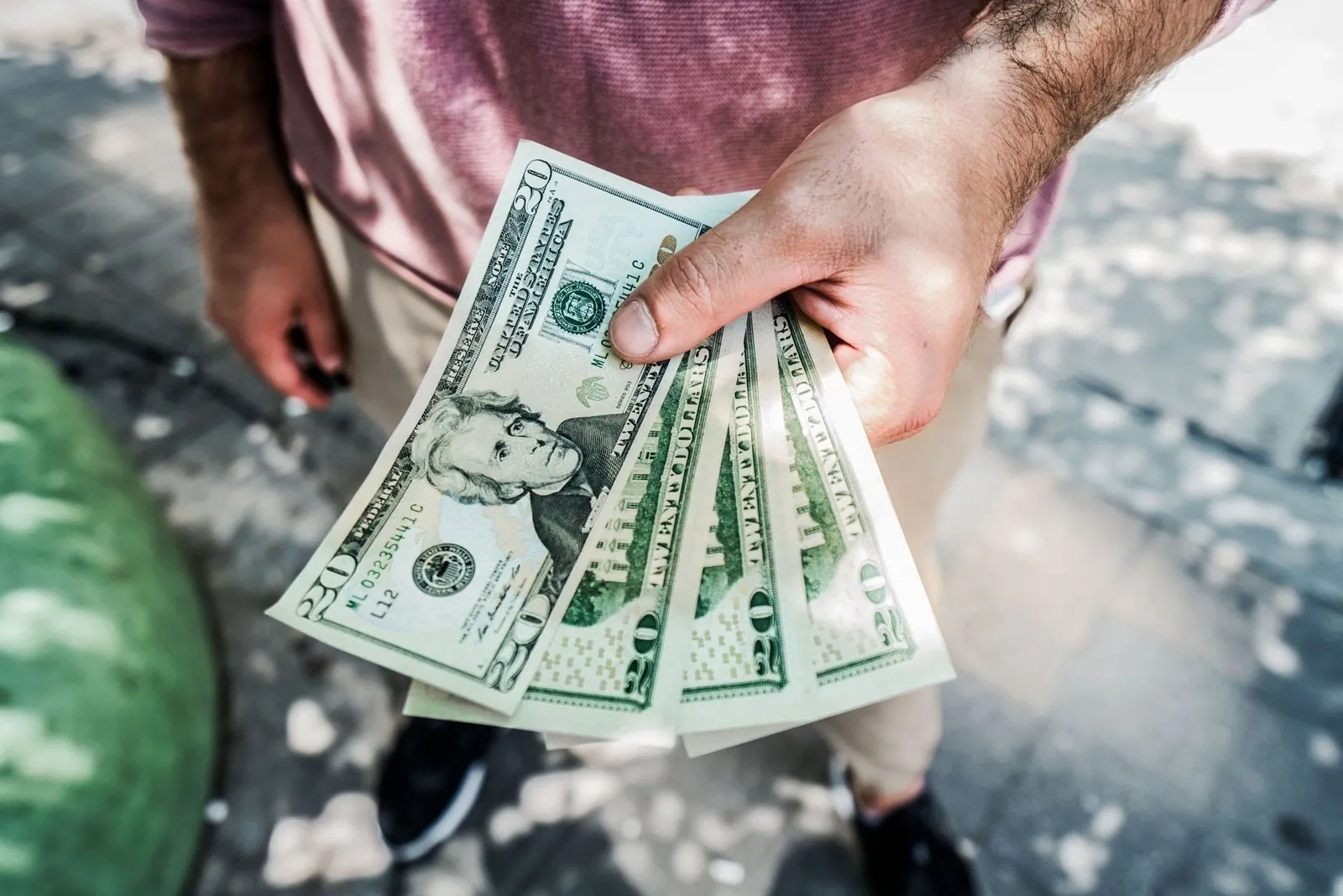 Hand holding US dollar bills
