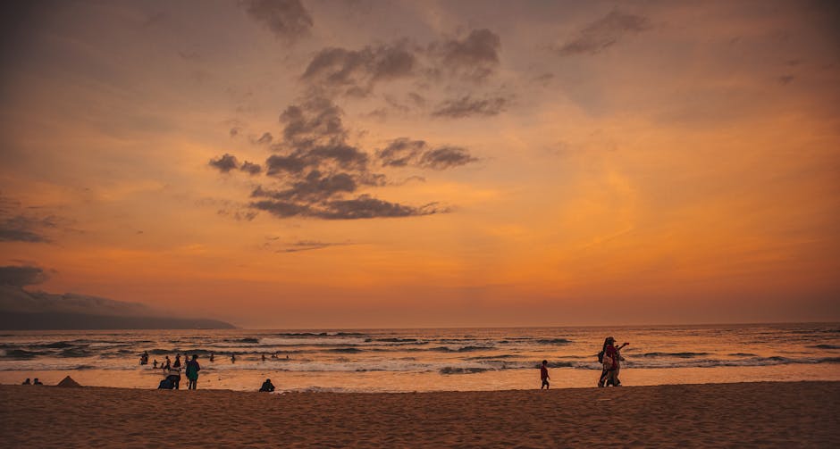 Da Nang beach at sunset with silhouettes of people and dramatic orange sky