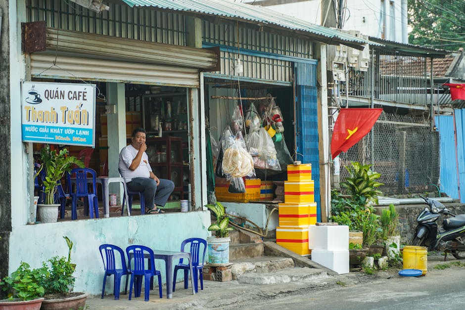 Local Vietnamese cafe Quan Cafe Thanh Tuan with Vietnamese flag, typical daily street life