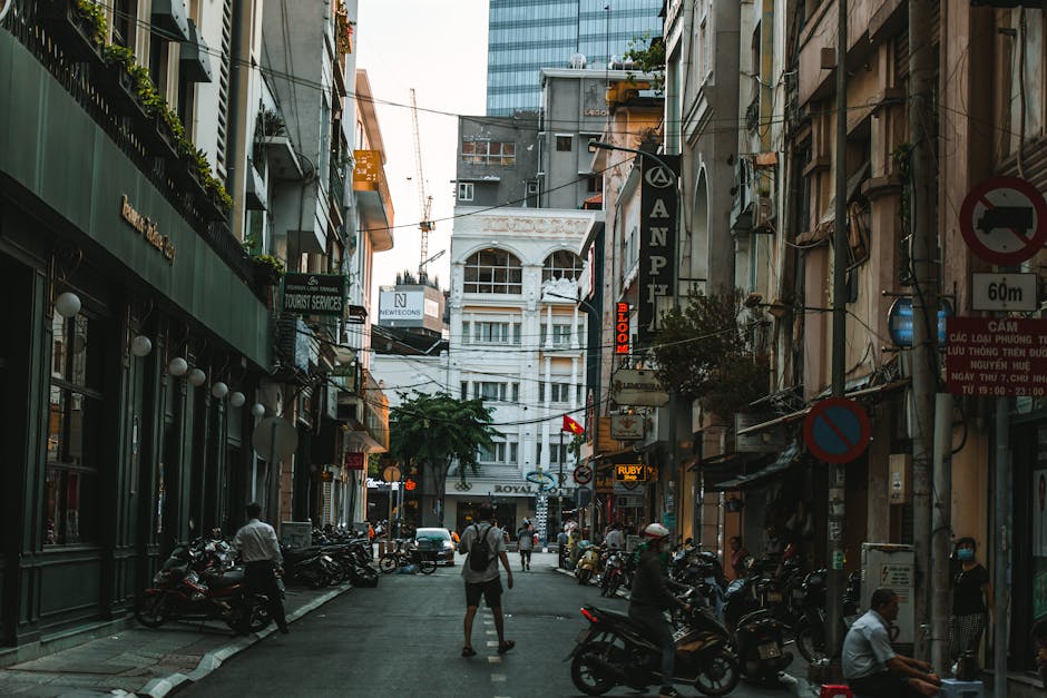 Narrow street in Ho Chi Minh City with motorbikes and Vietnamese shop signs