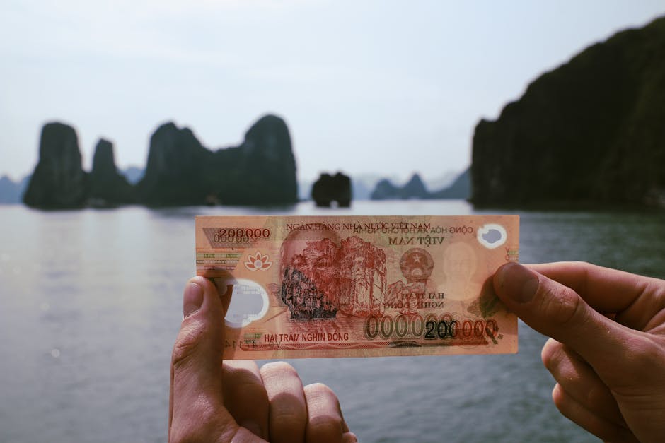 200,000 Vietnamese dong banknote held up against Ha Long Bay