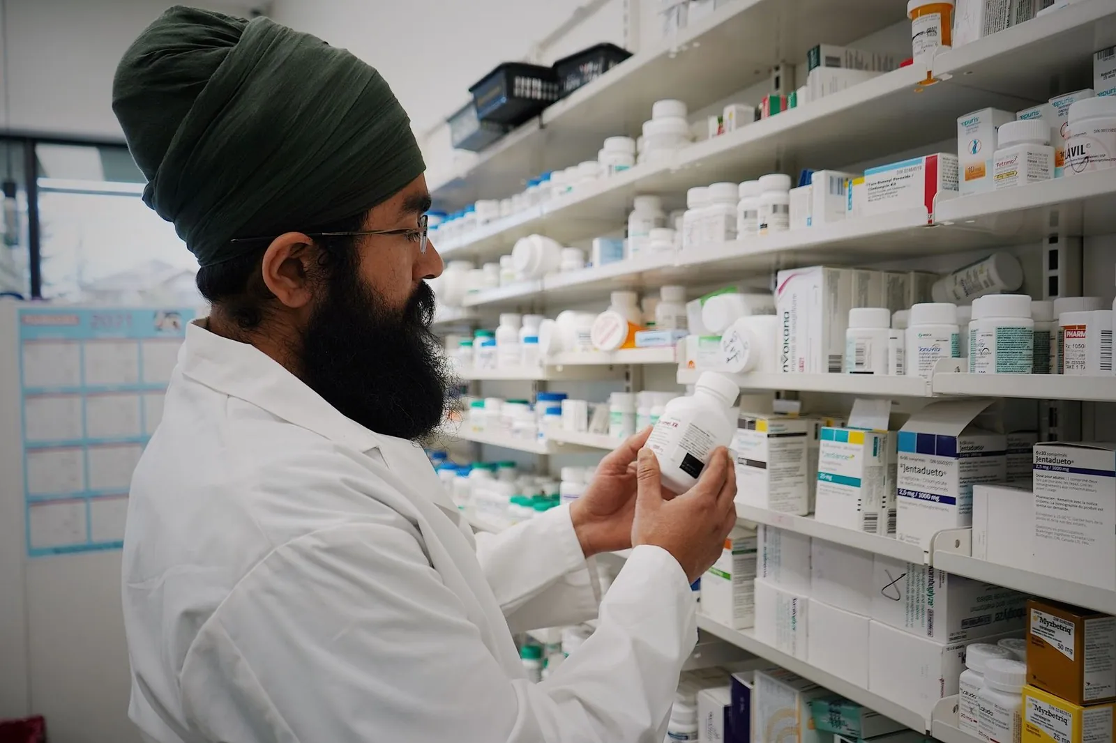Pharmacist checking medicine on pharmacy shelves