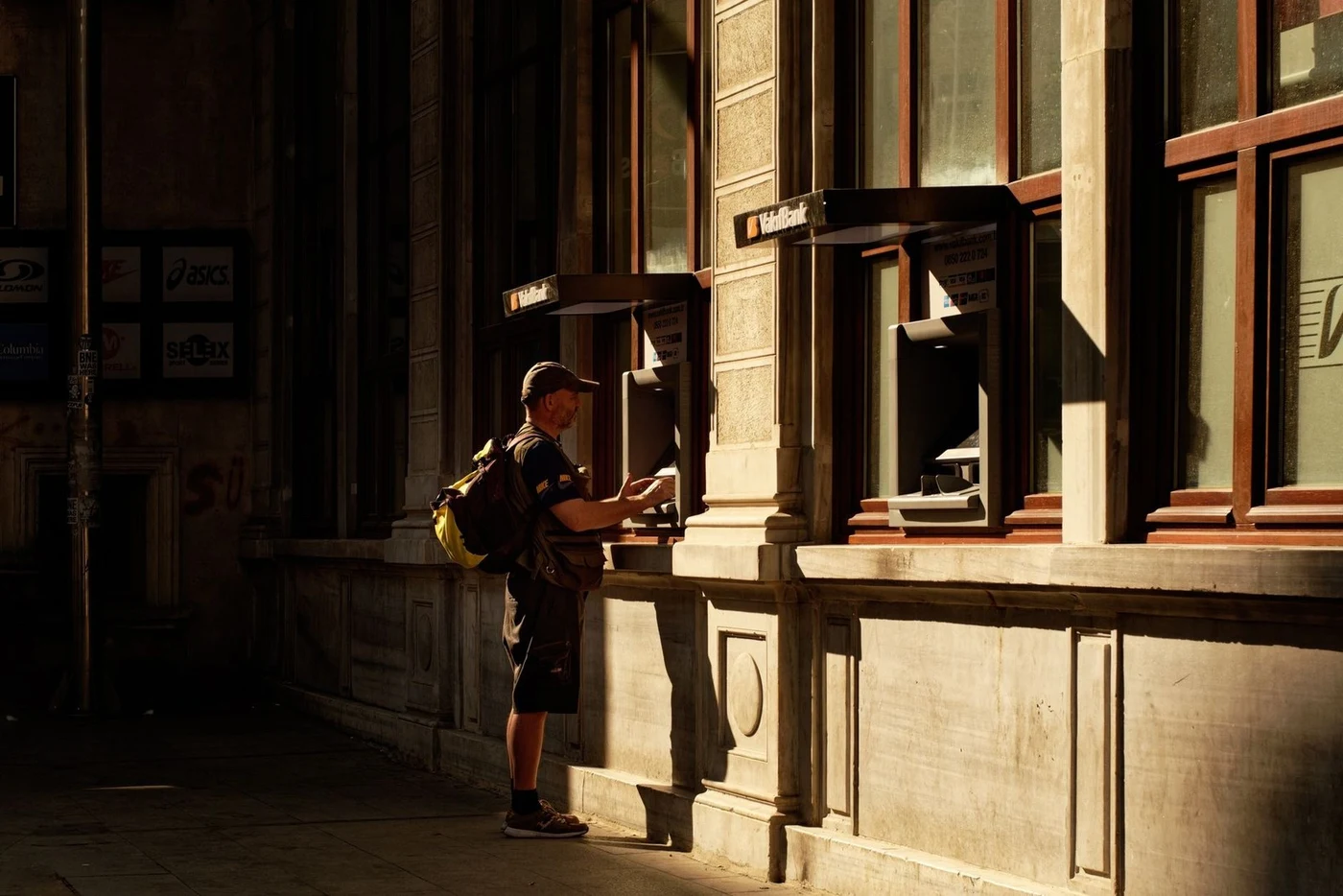 A person withdrawing cash from a street ATM