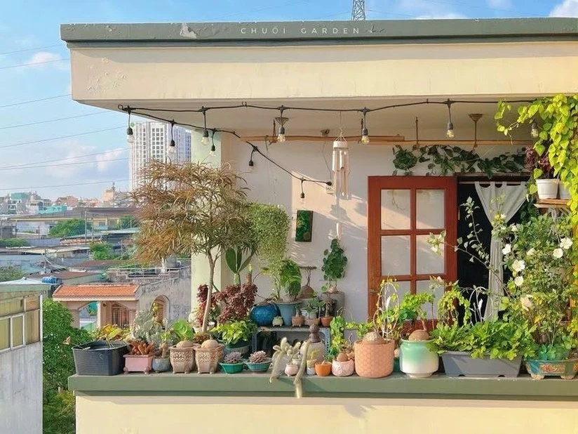 Small rooftop apartment terrace with plants and string lights in Ho Chi Minh City