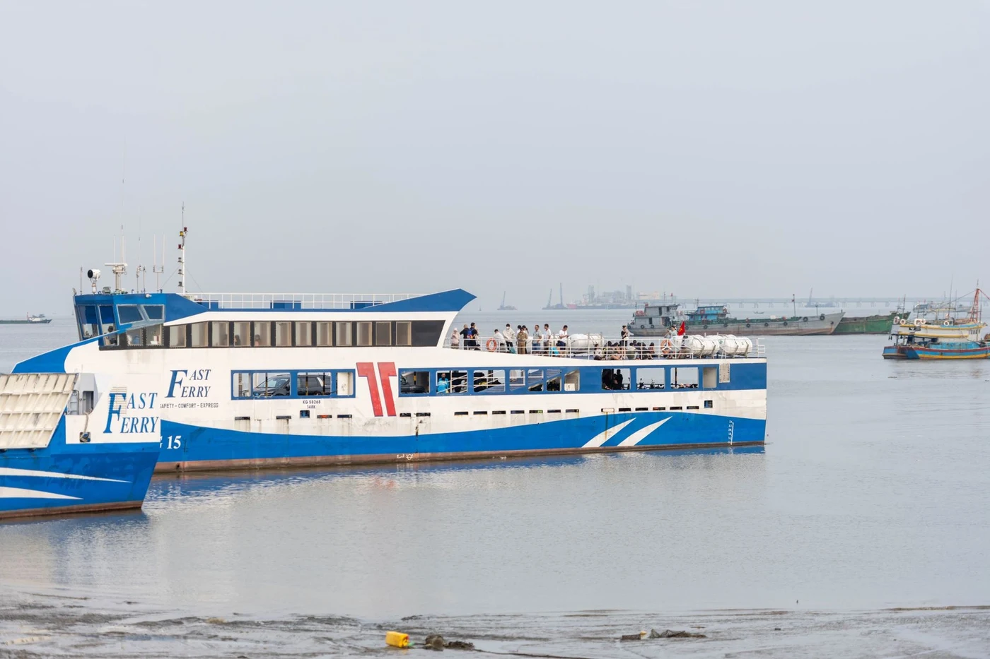 Blue and white Fast Ferry passenger catamaran moored in shallow water near Vung Tau