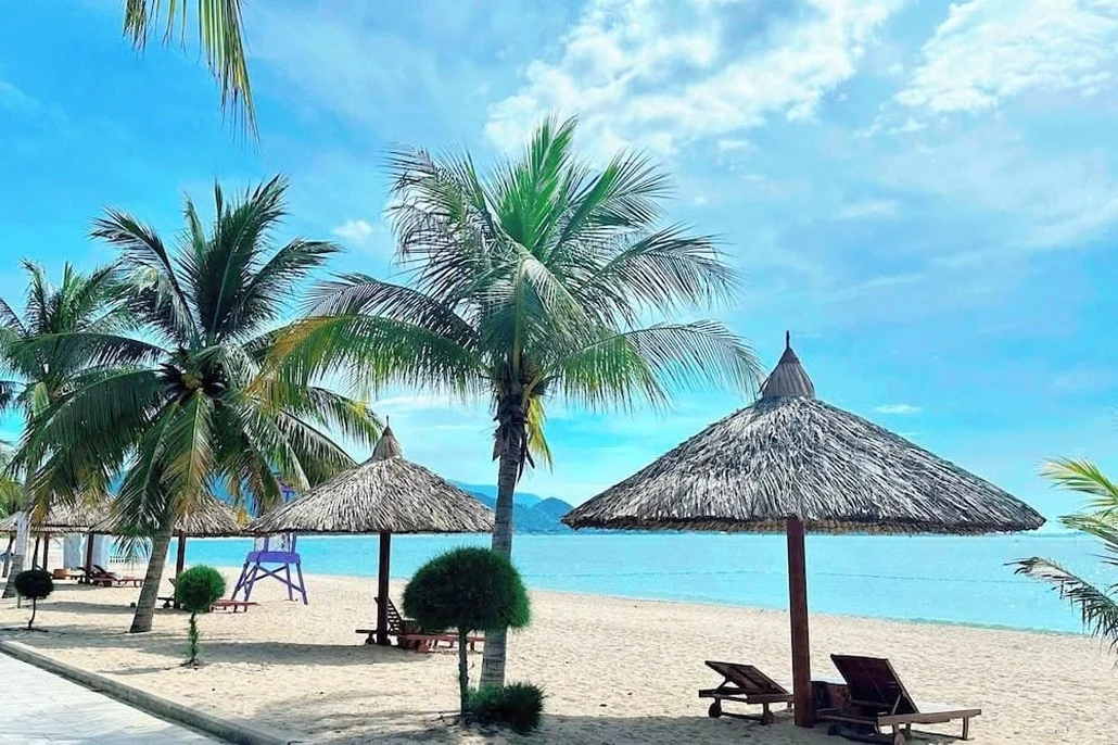 Sun loungers under thatched shades on the beach in Nha Trang
