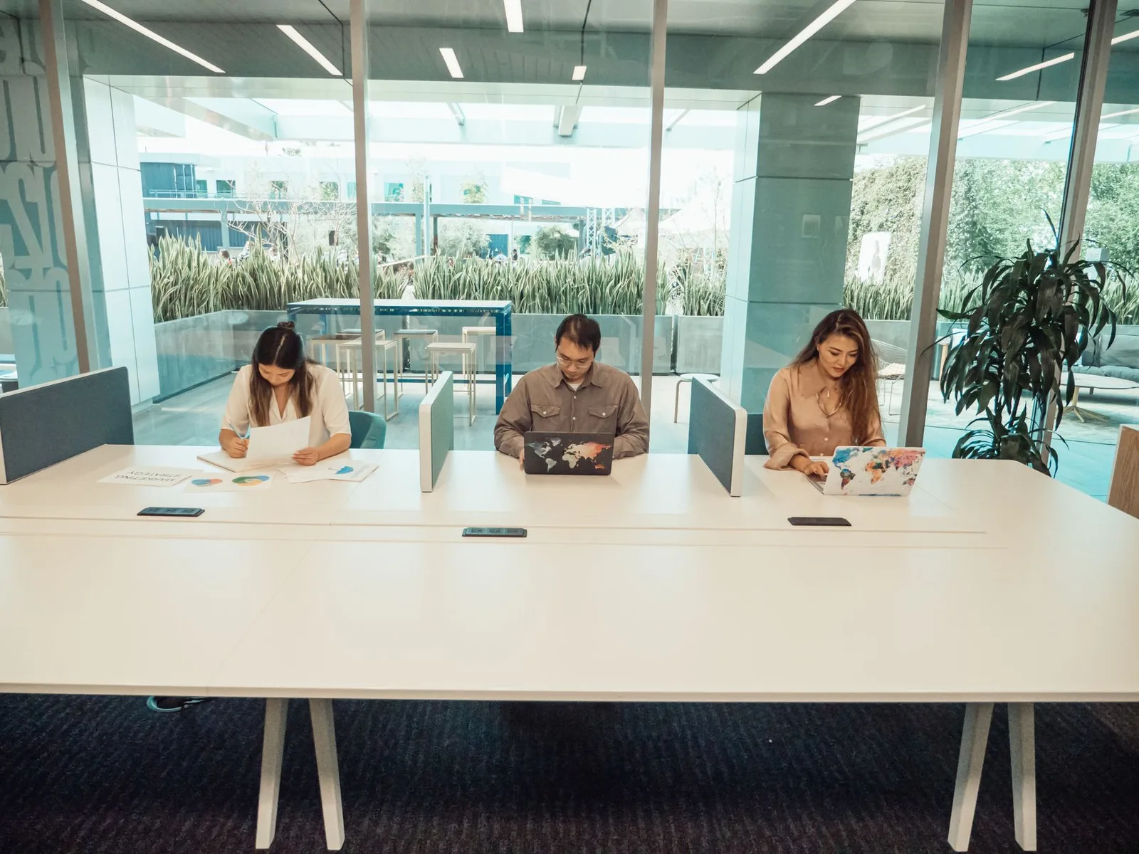 Shared desks with people working on laptops in a modern coworking space