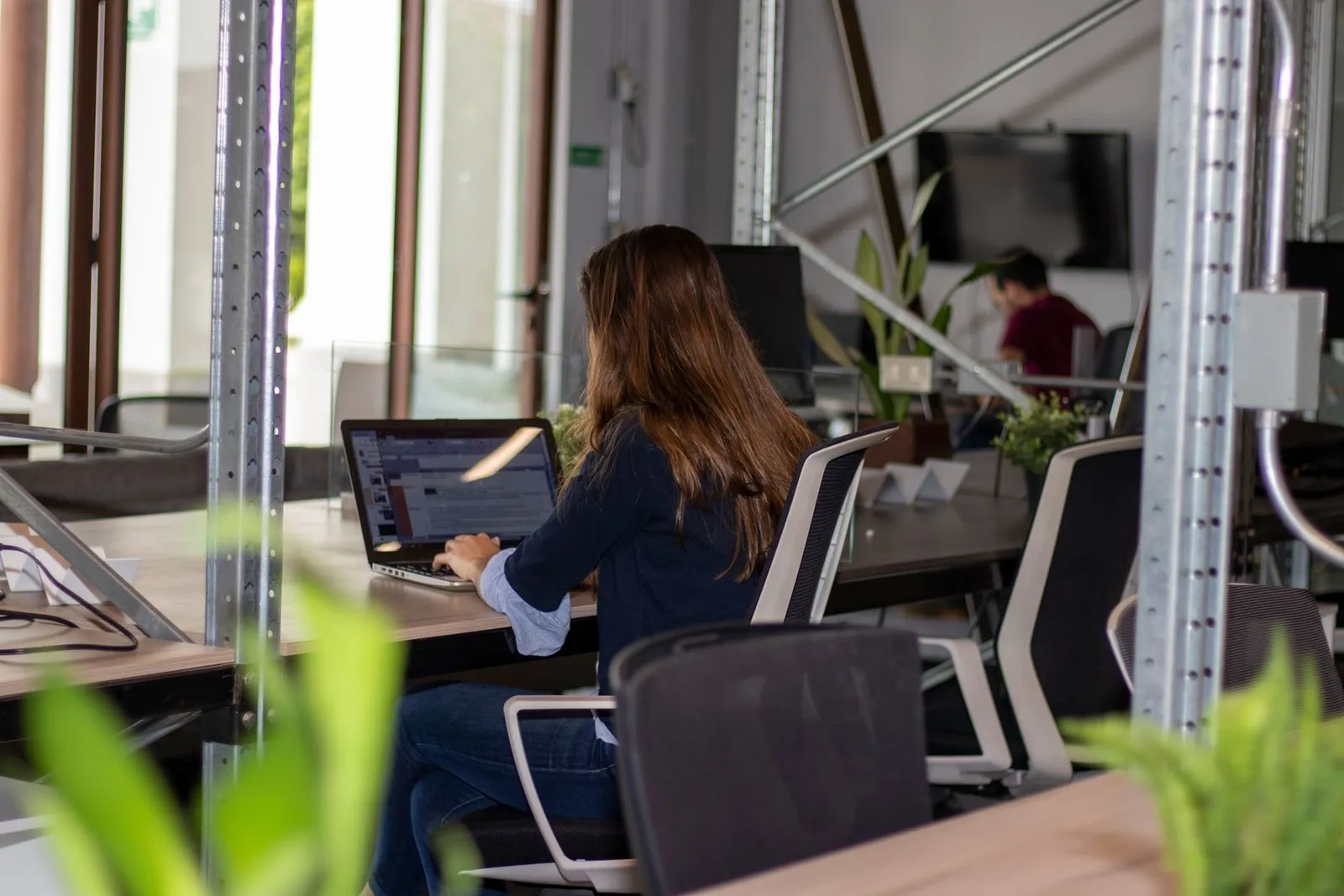 Woman working on a laptop inside a modern coworking space