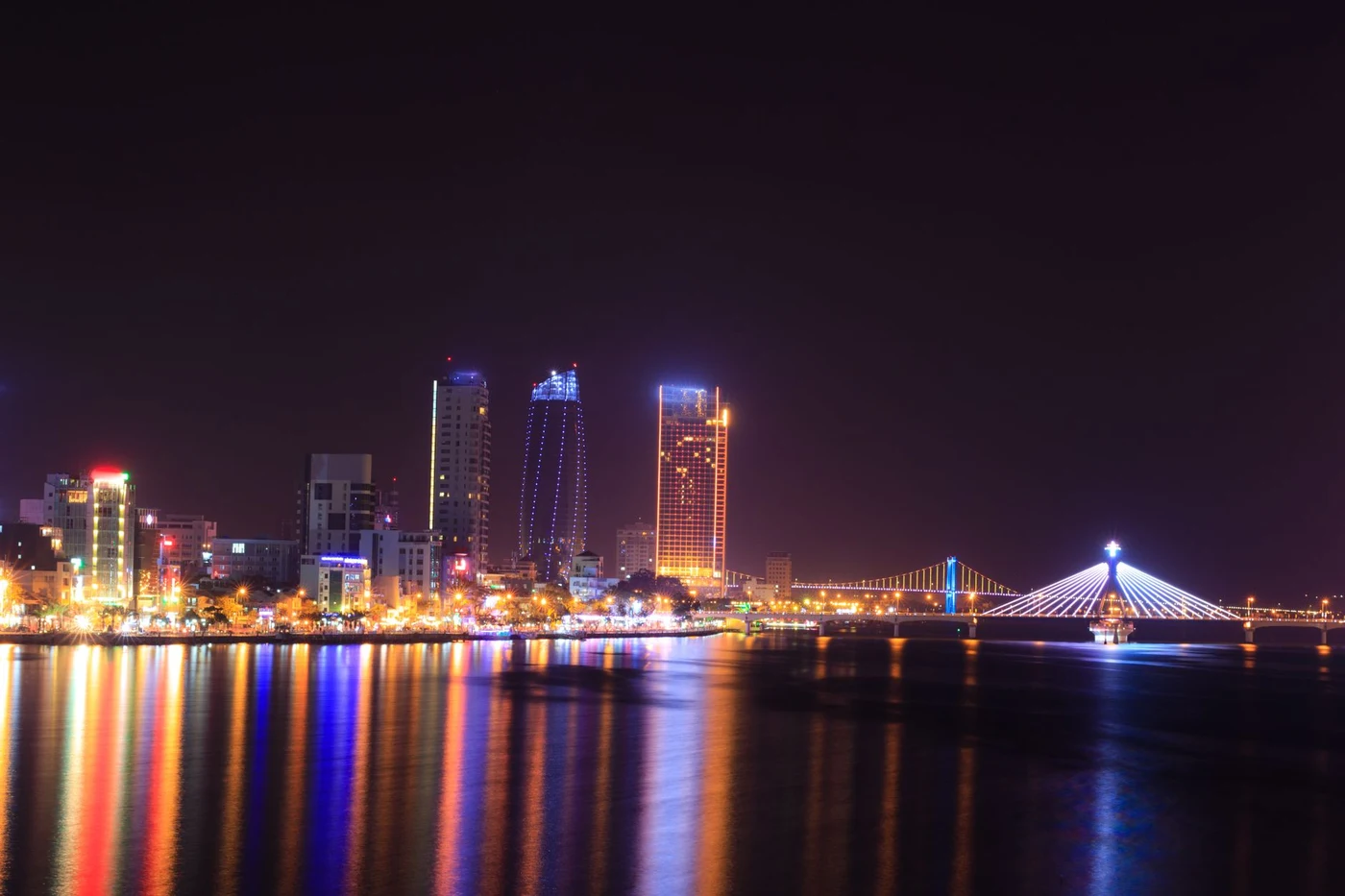 Da Nang city skyline at night with the illuminated Han River bridge