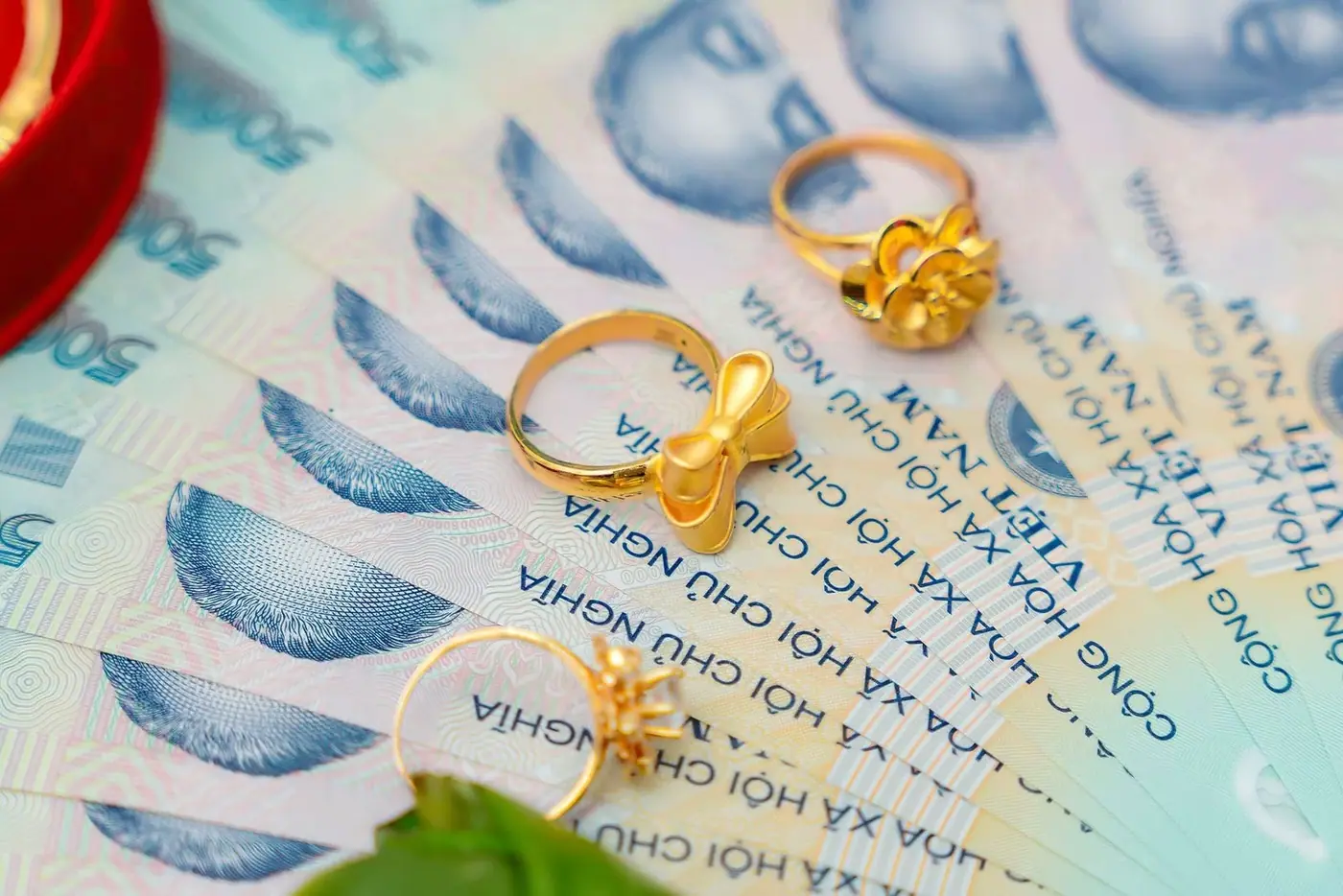 Gold rings resting on stacks of Vietnamese dong banknotes at a jewelry counter