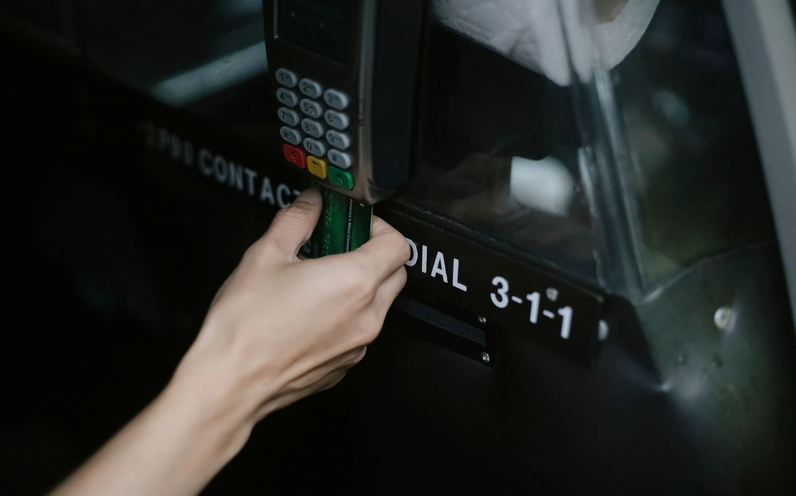 A hand inserting a bank card into a payment terminal