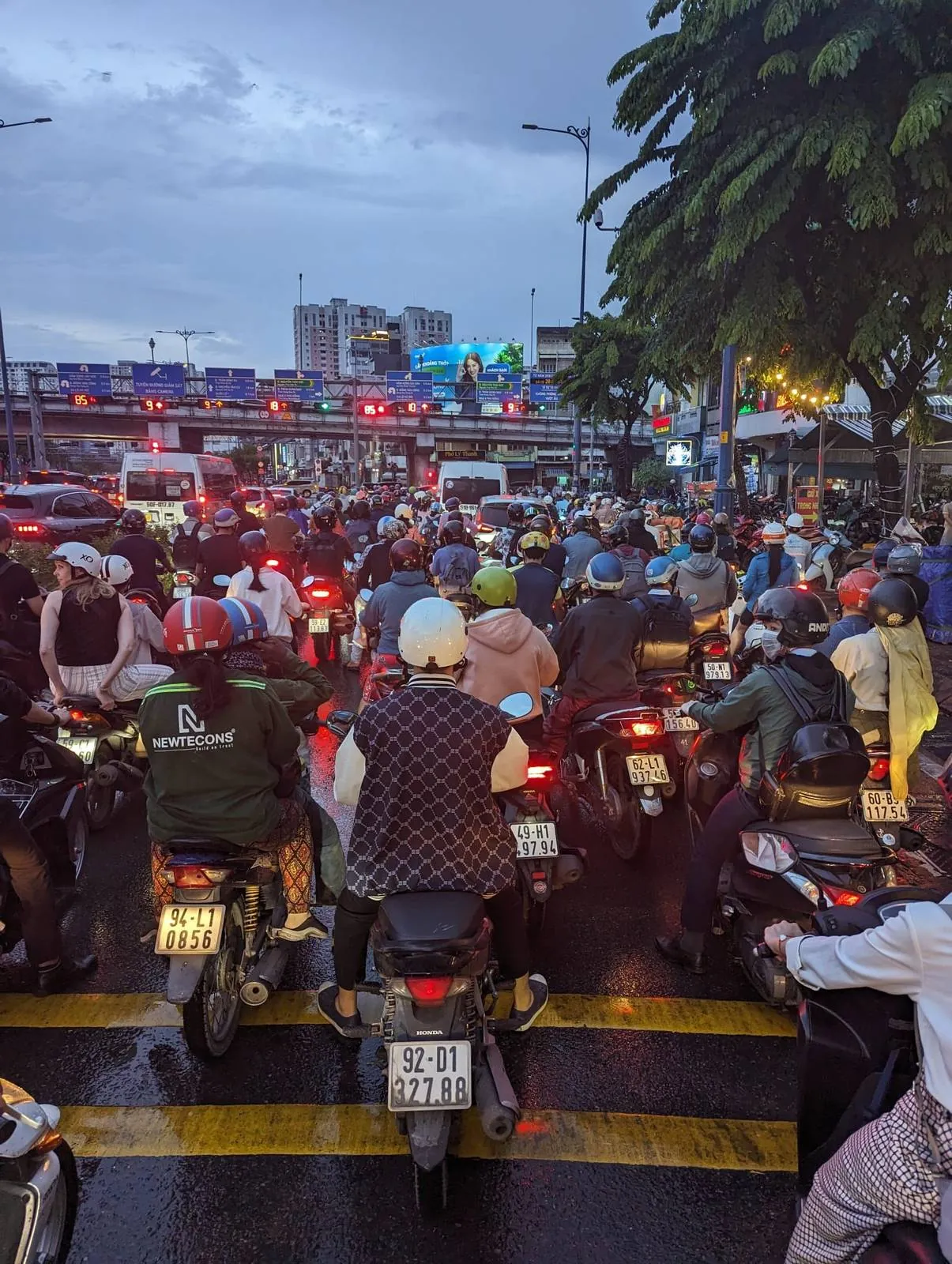 Motorbike riders stopped at a red light in heavy Ho Chi Minh City traffic at dusk