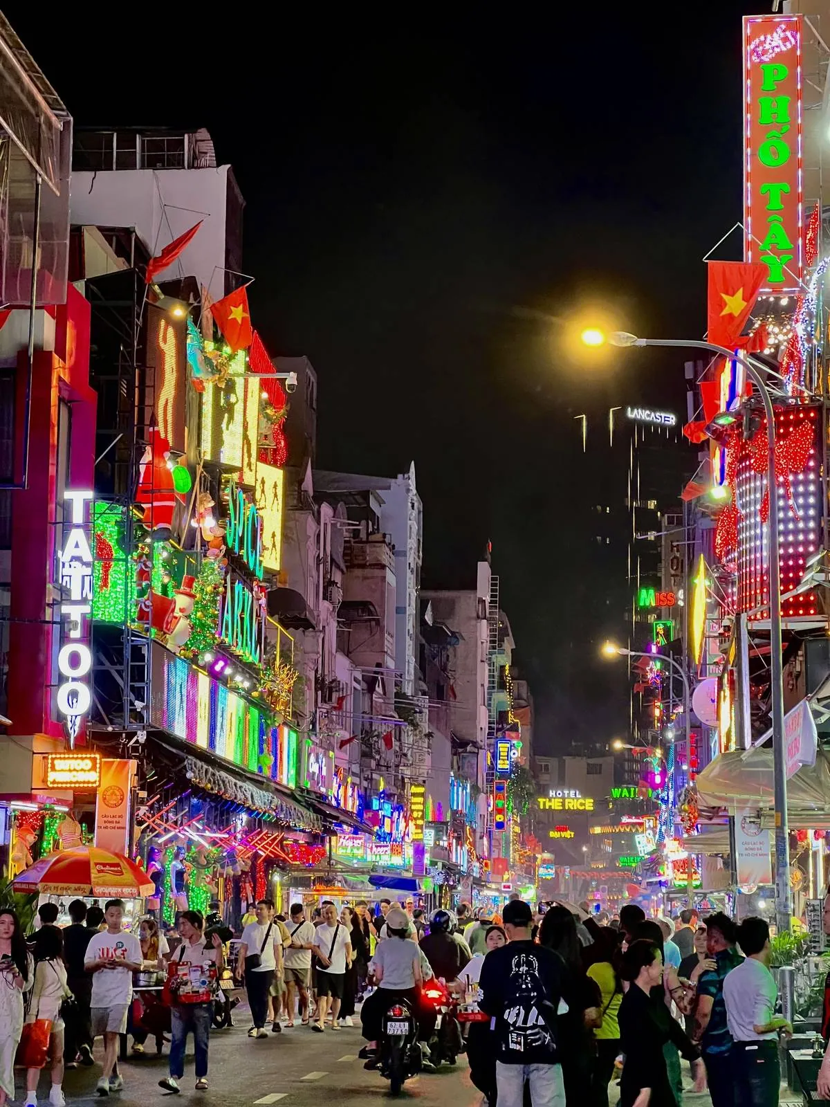Crowds and motorbikes on Pho Tay street in Ho Chi Minh City at night