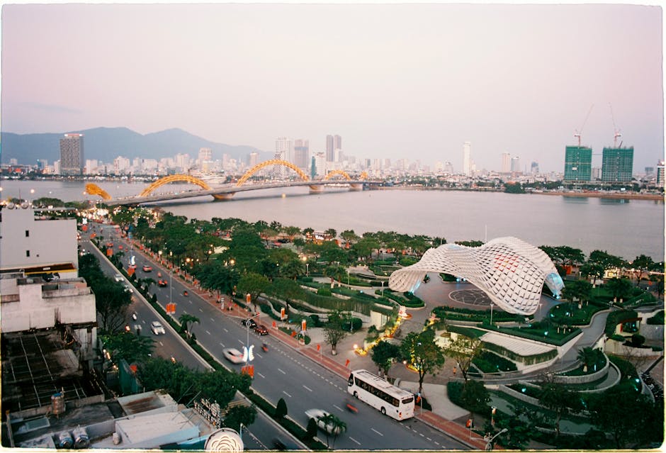 Dragon Bridge in Da Nang at sunset with the Hàn River and a bus crossing the promenade