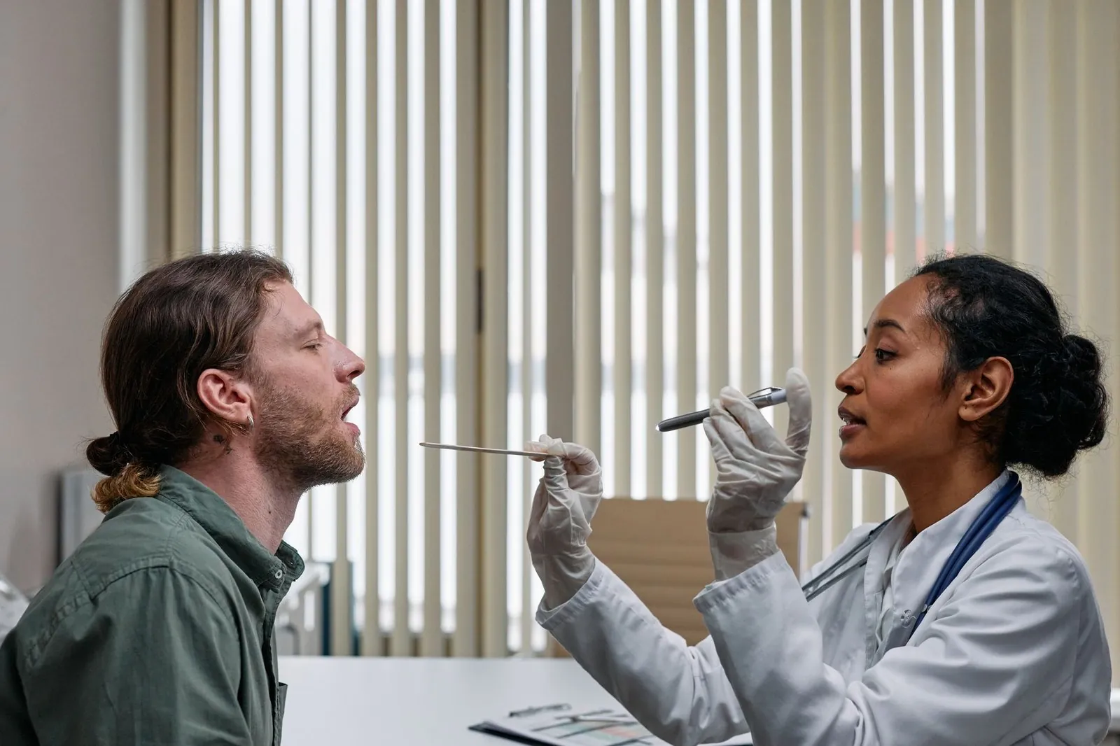 Doctor examining a patient’s throat during a clinic consultation