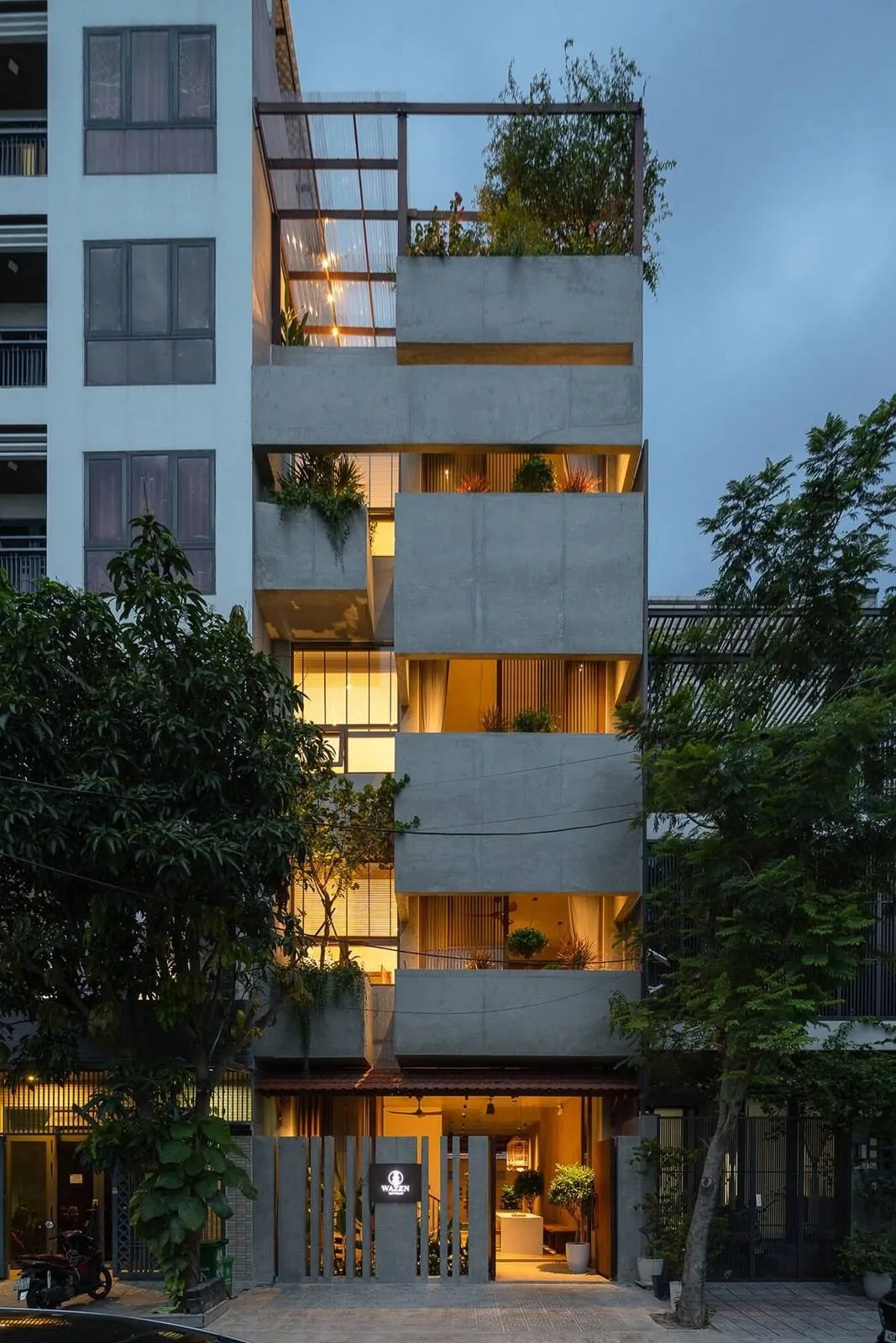 Concrete apartment building lit up at dusk in Da Nang