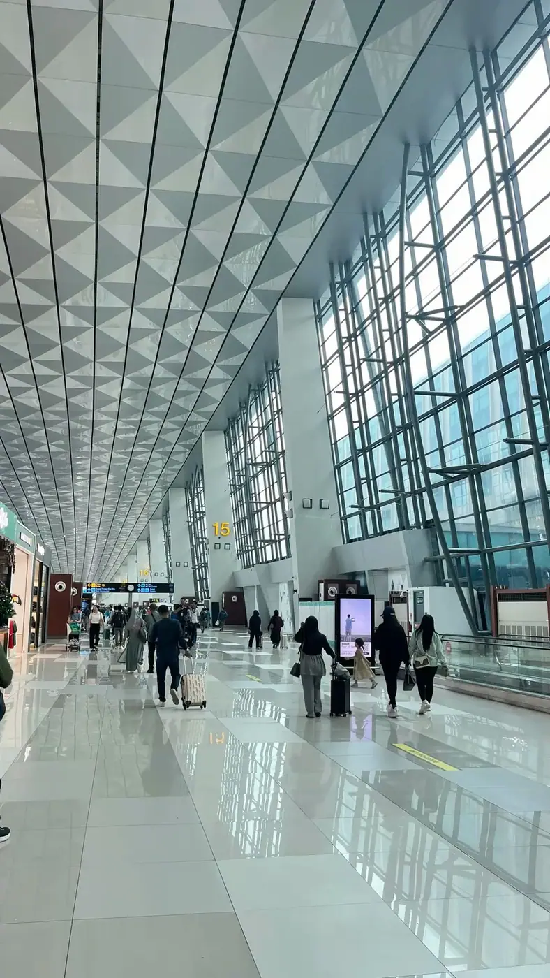 Travelers walking through a modern airport terminal before boarding