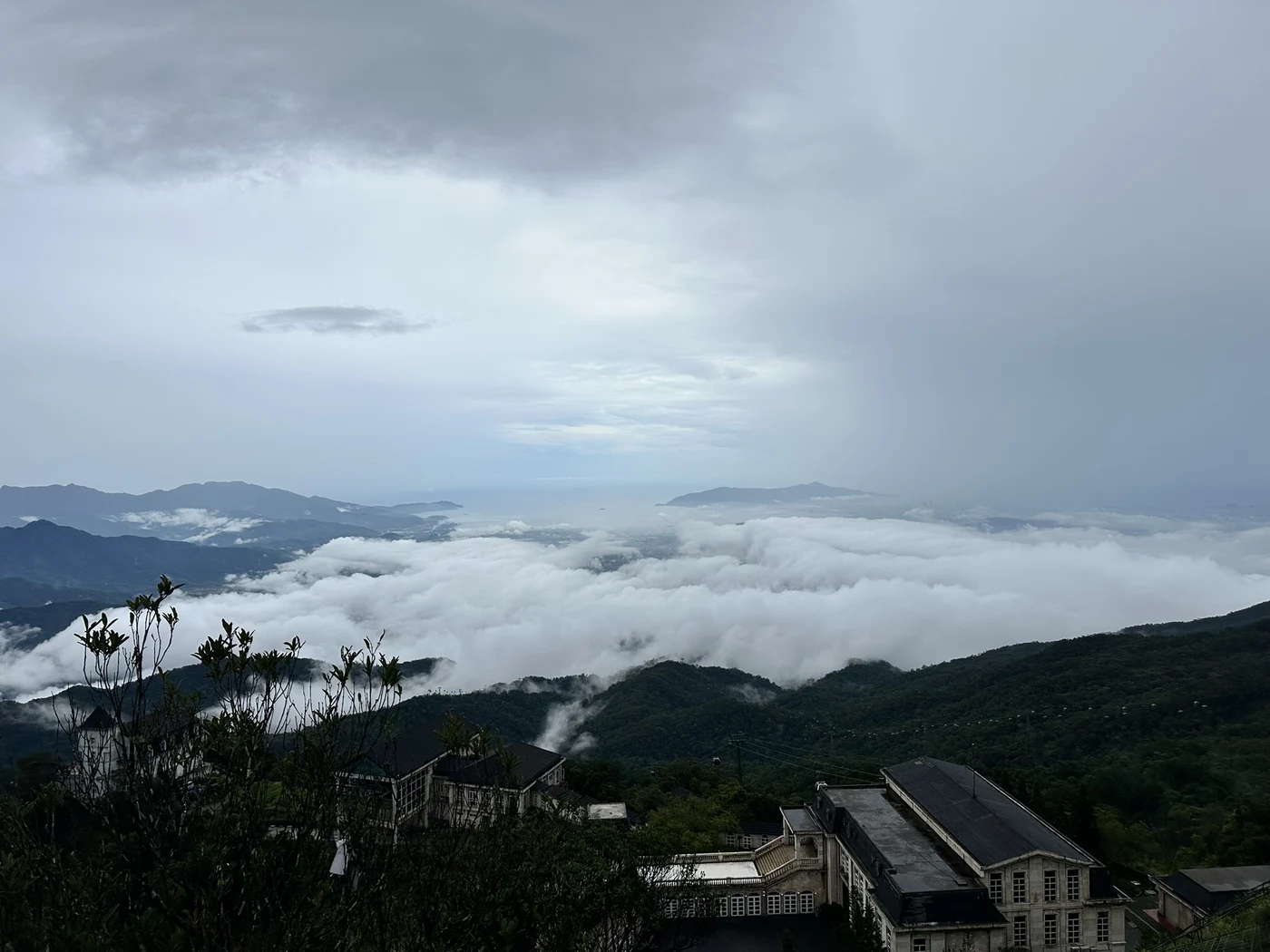 Sea of clouds over green hills at Ba Na Hills near Da Nang under a grey sky