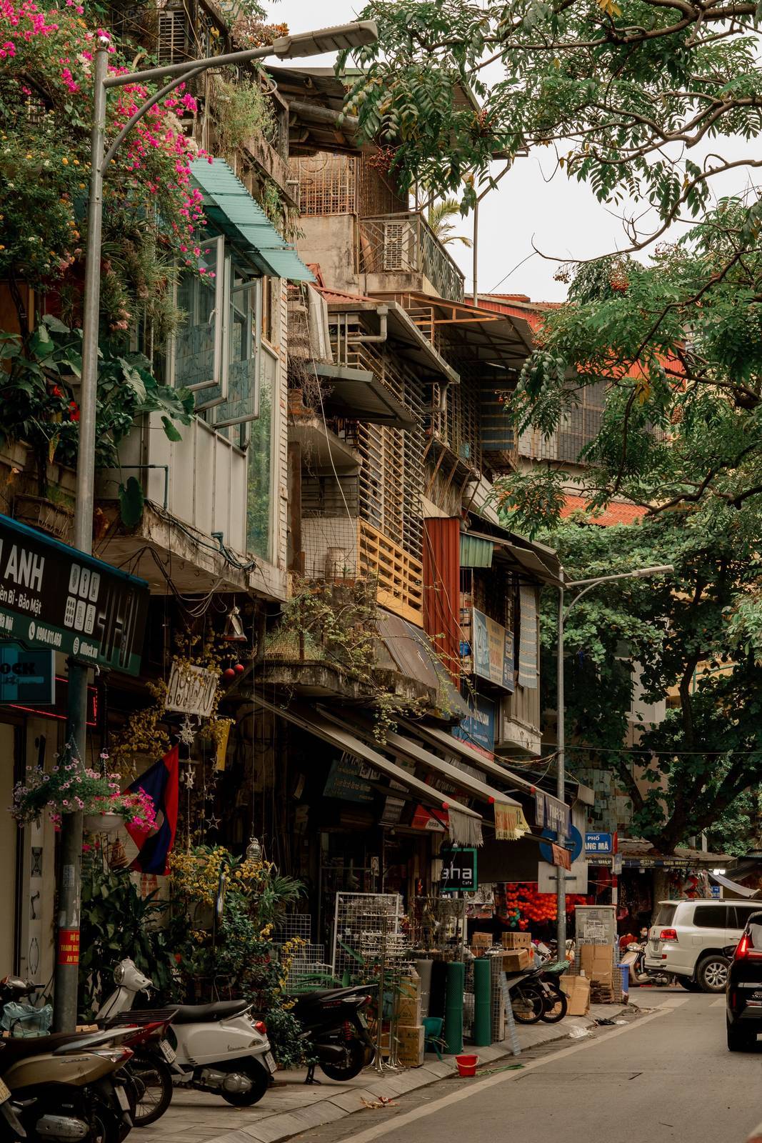 Narrow street in a Vietnamese old quarter with motorbikes parked outside shops