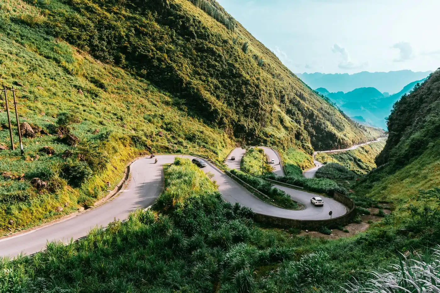 Winding mountain road cutting through green hills in central Vietnam