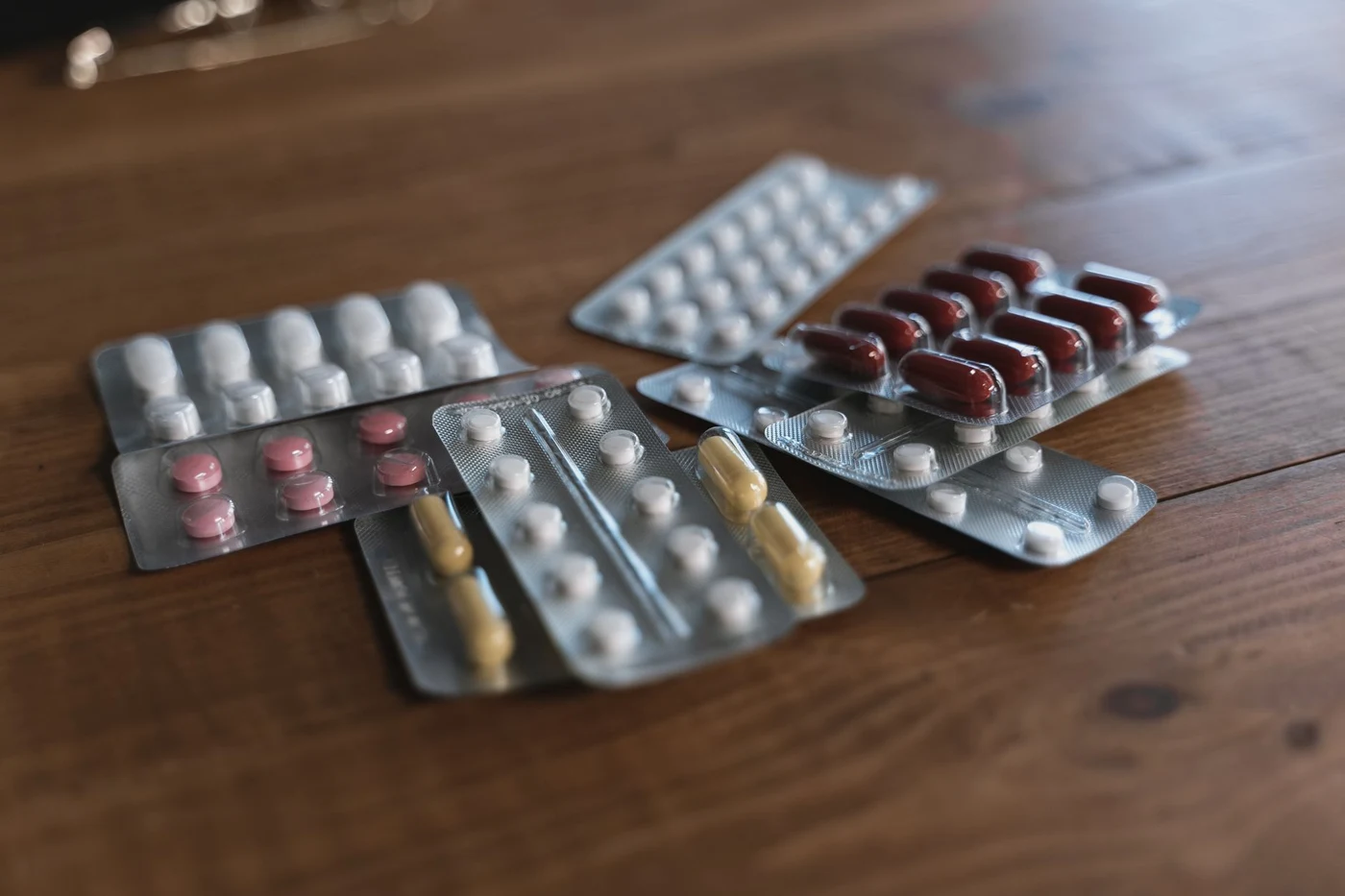 Blister packs with tablets and capsules laid out on a table