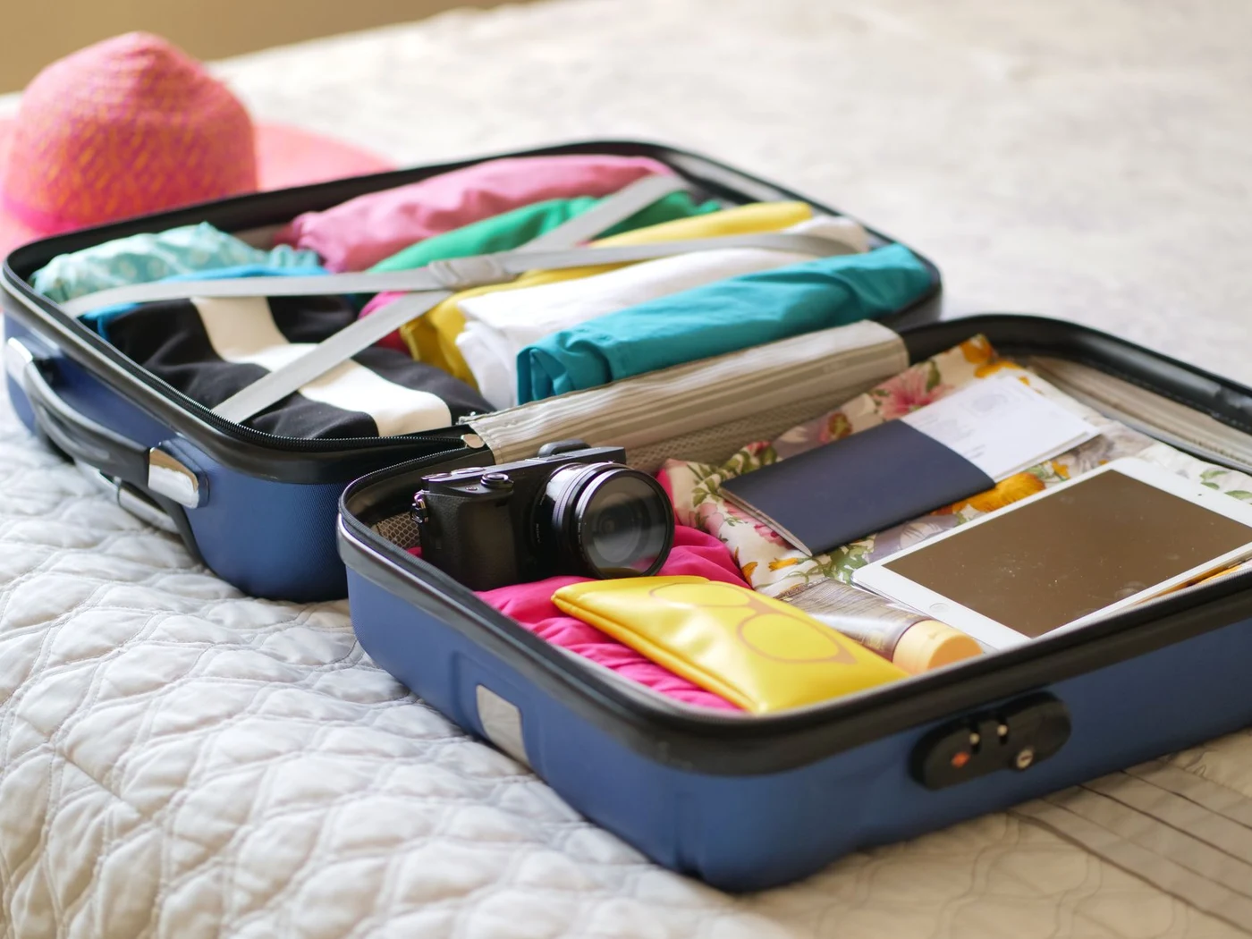 Open suitcase with a passport and clothes being packed