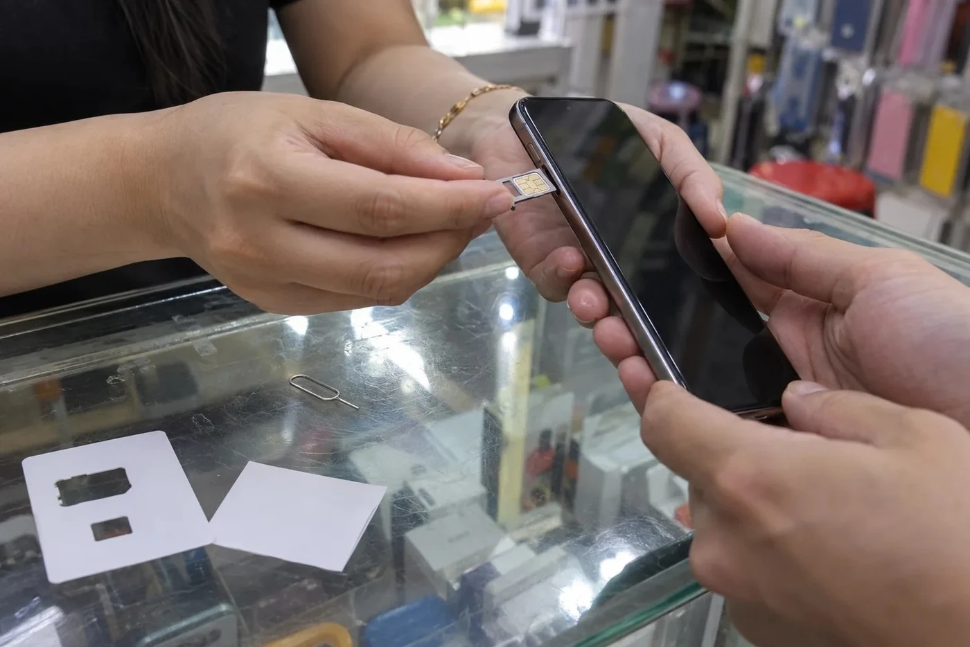 Tourist buying a local SIM card at an airport counter, passport on the desk