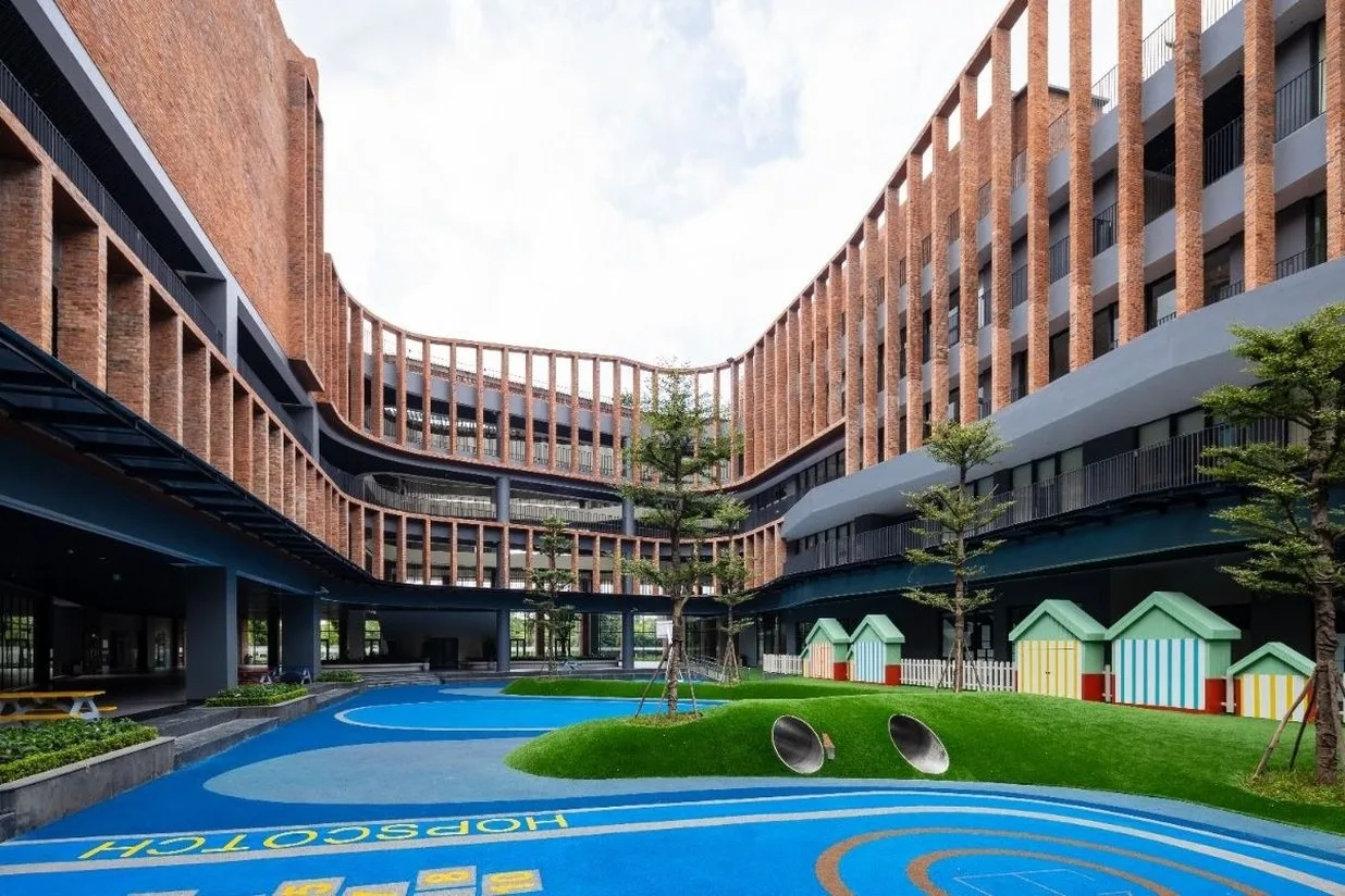 Brick school building around a courtyard with painted hopscotch squares