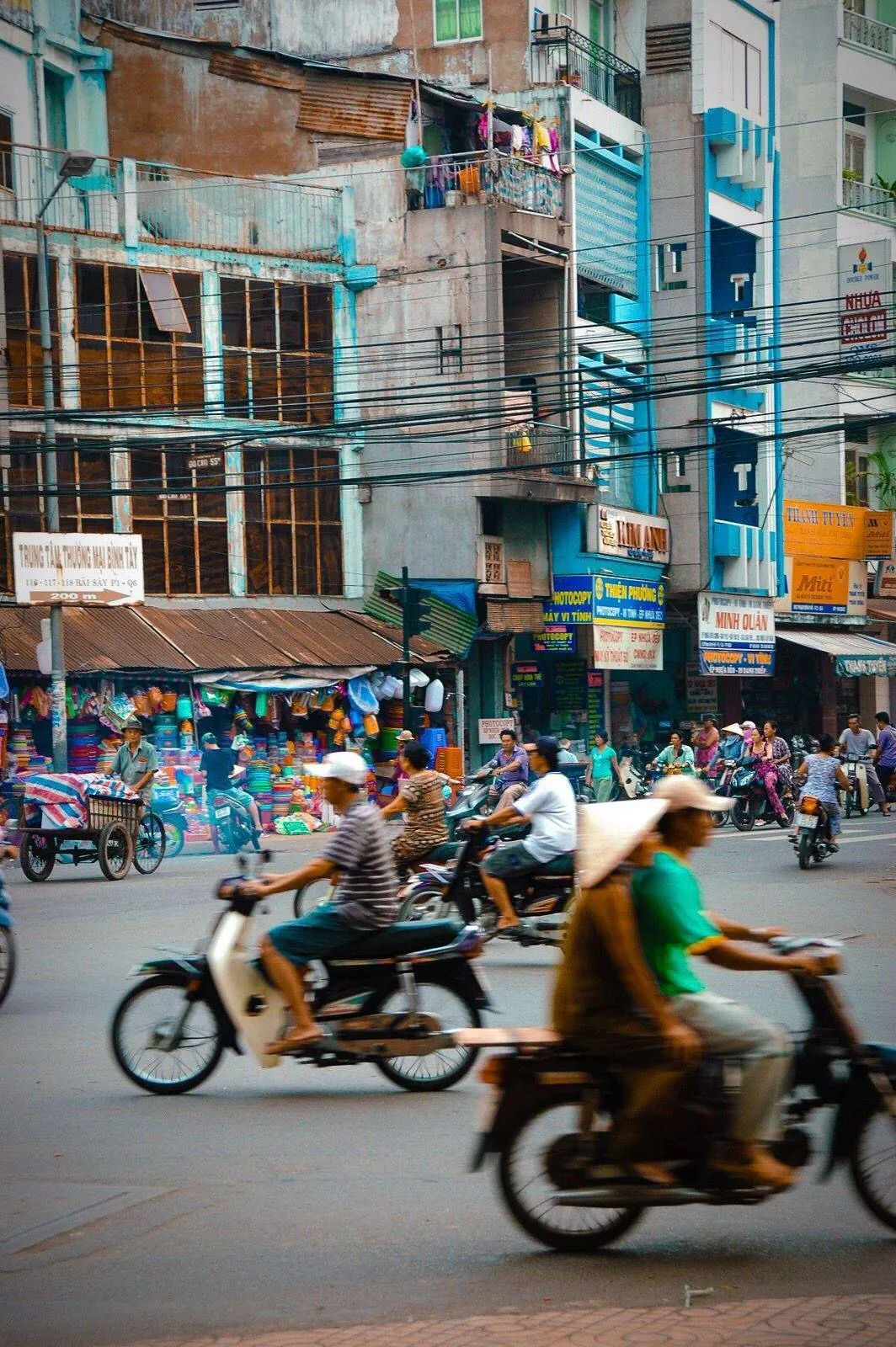 Busy Ho Chi Minh City street with motorbikes and shop signs