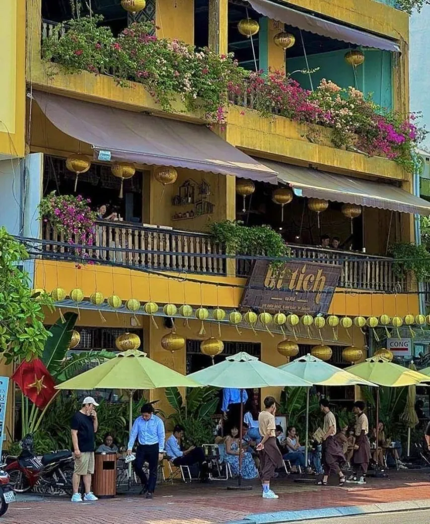 Yellow colonial building with lanterns and a street cafe in Hoi An