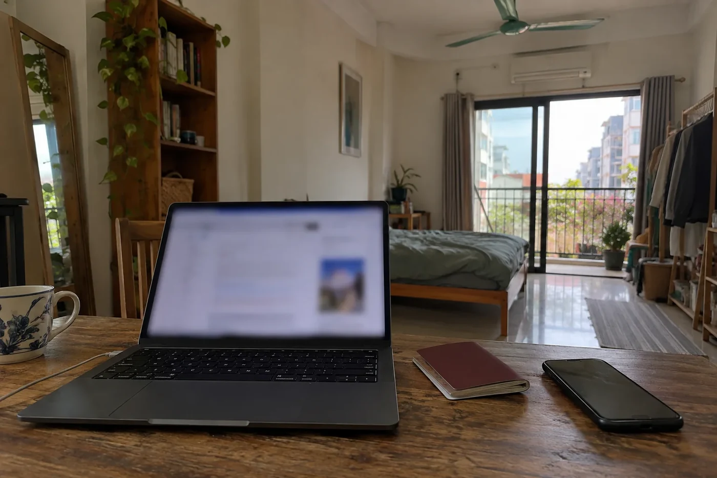 Laptop on a desk with an online visa application next to a passport and a phone