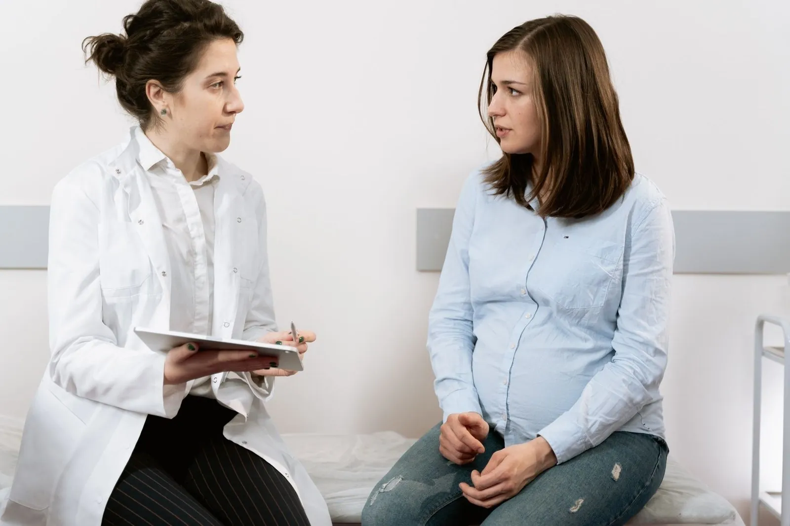 Pregnant woman discussing prenatal care with her doctor