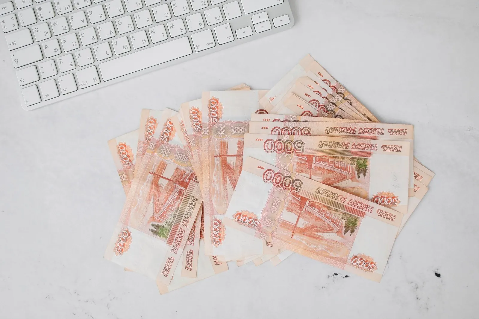 Stack of Russian 5,000 ruble banknotes next to a computer keyboard