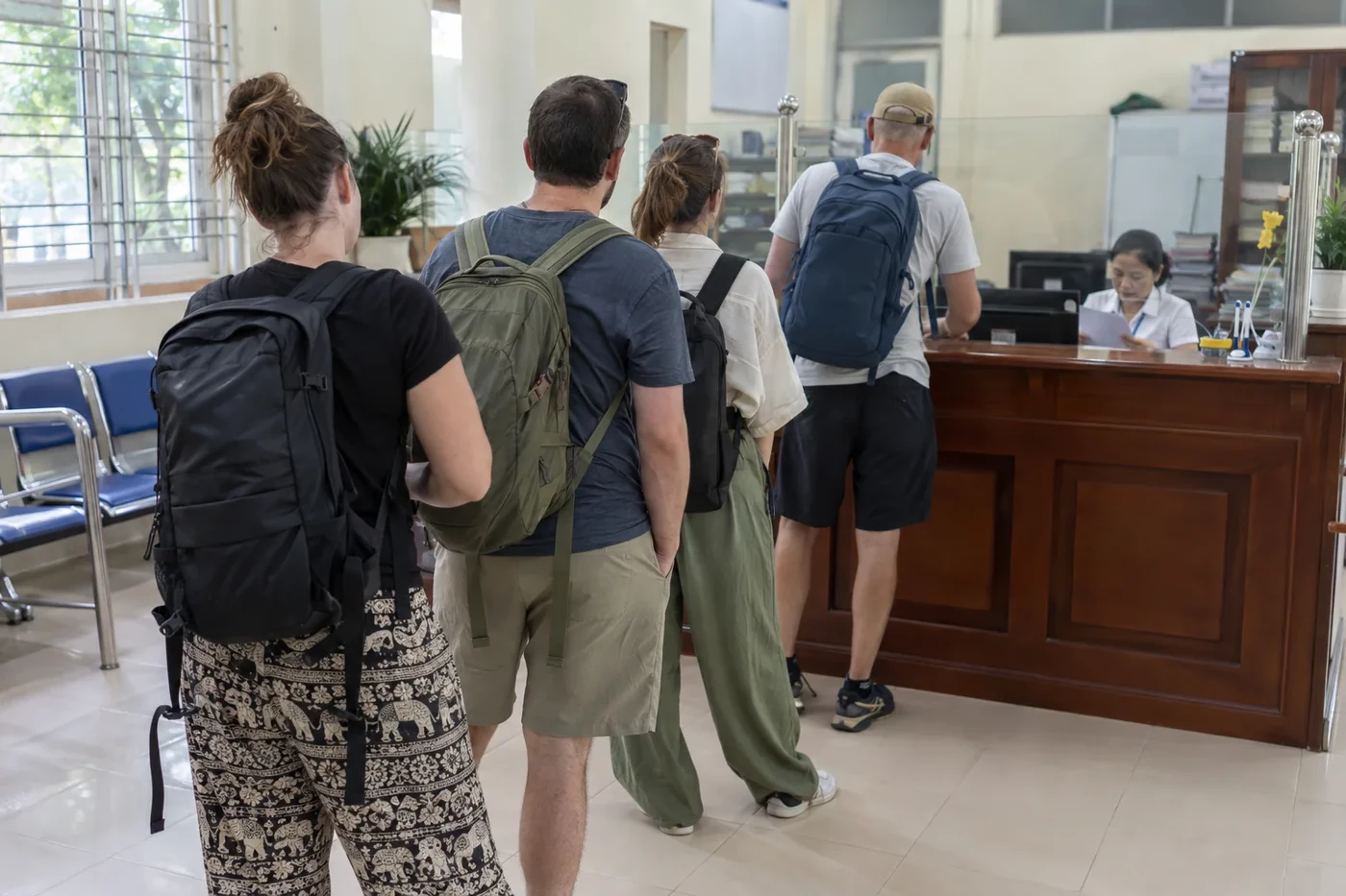 Travelers in a queue to a reception counter in a government office