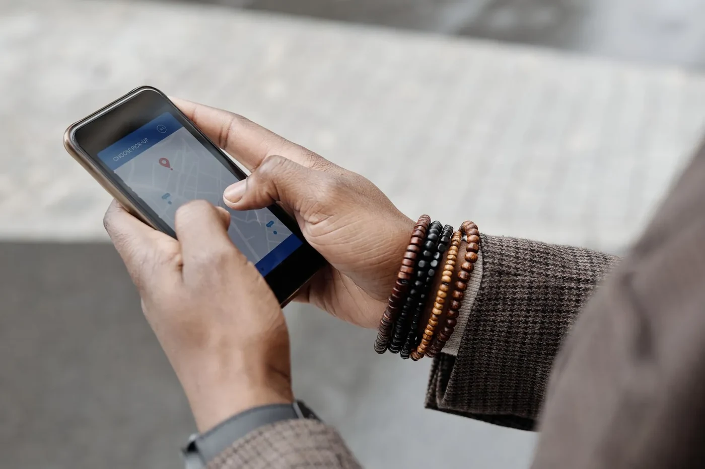 Two hands holding a smartphone with a map app open on the screen