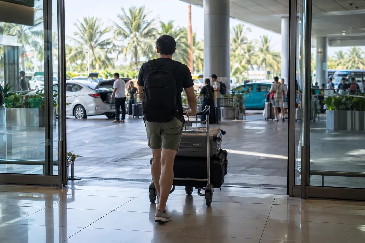 Traveller with luggage trolley in an airport arrival hall