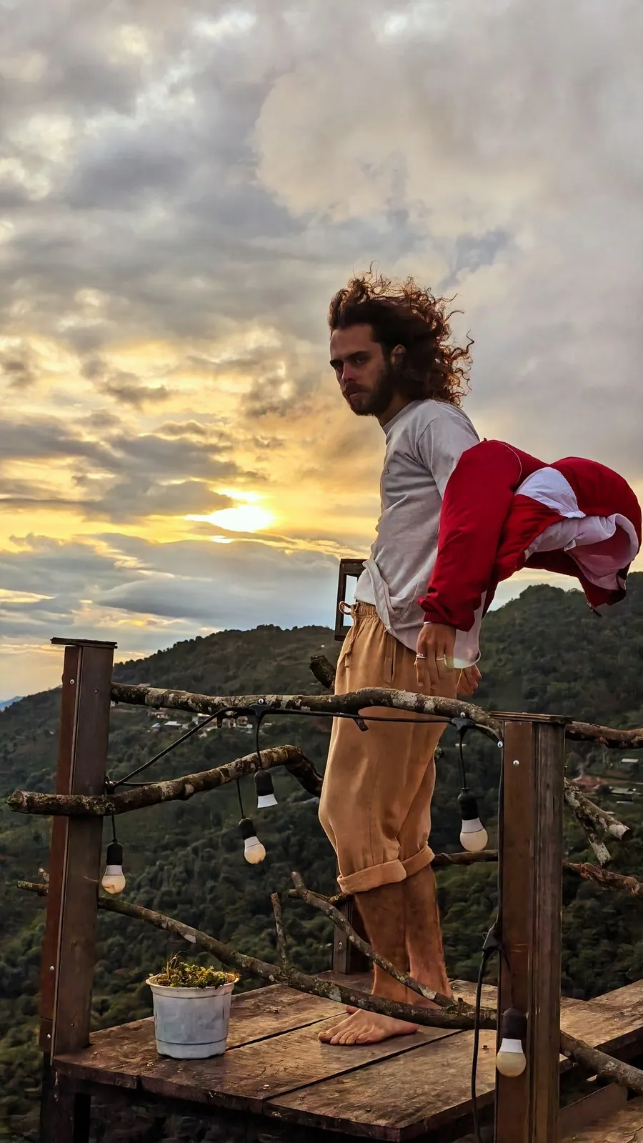 Man on a wooden terrace at sunset in the Vietnamese mountains