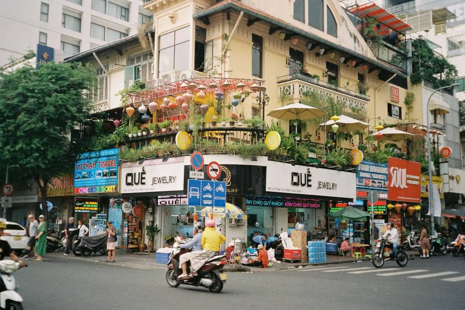 Busy street corner with shops and motorbikes in Da Nang