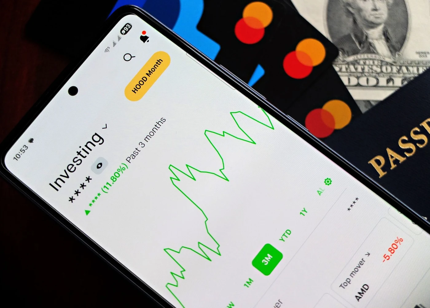 Smartphone showing a banking app next to a passport and cards