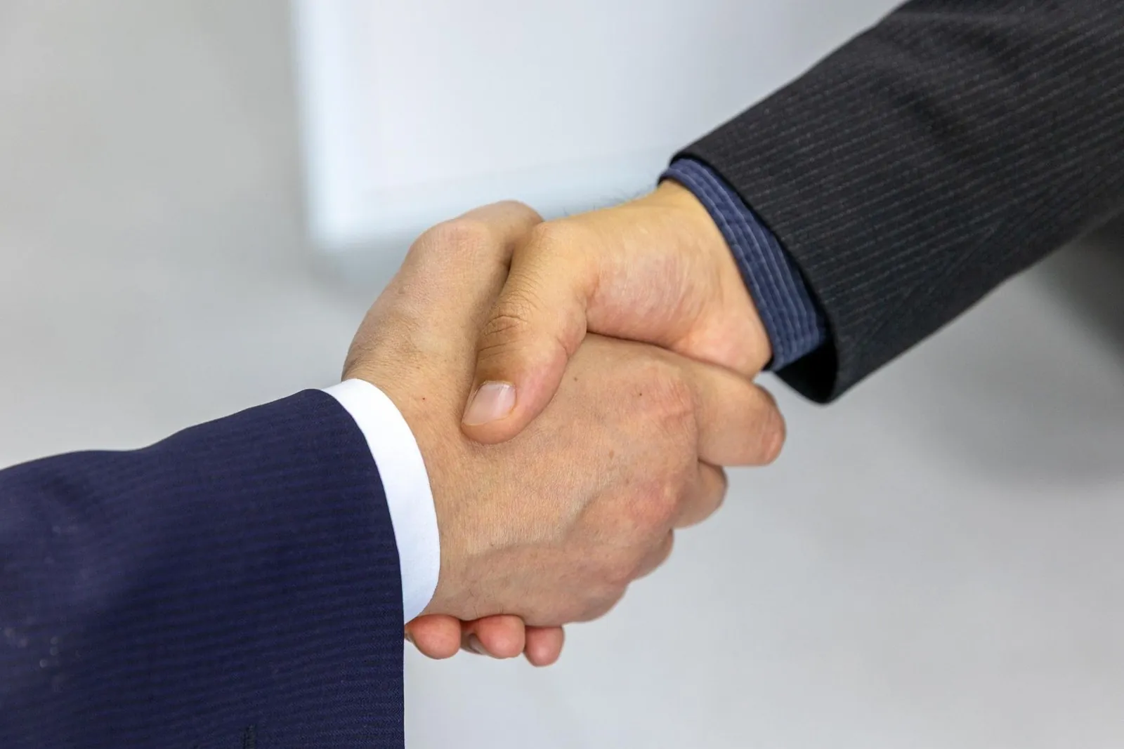 Close-up handshake between two people in business suits