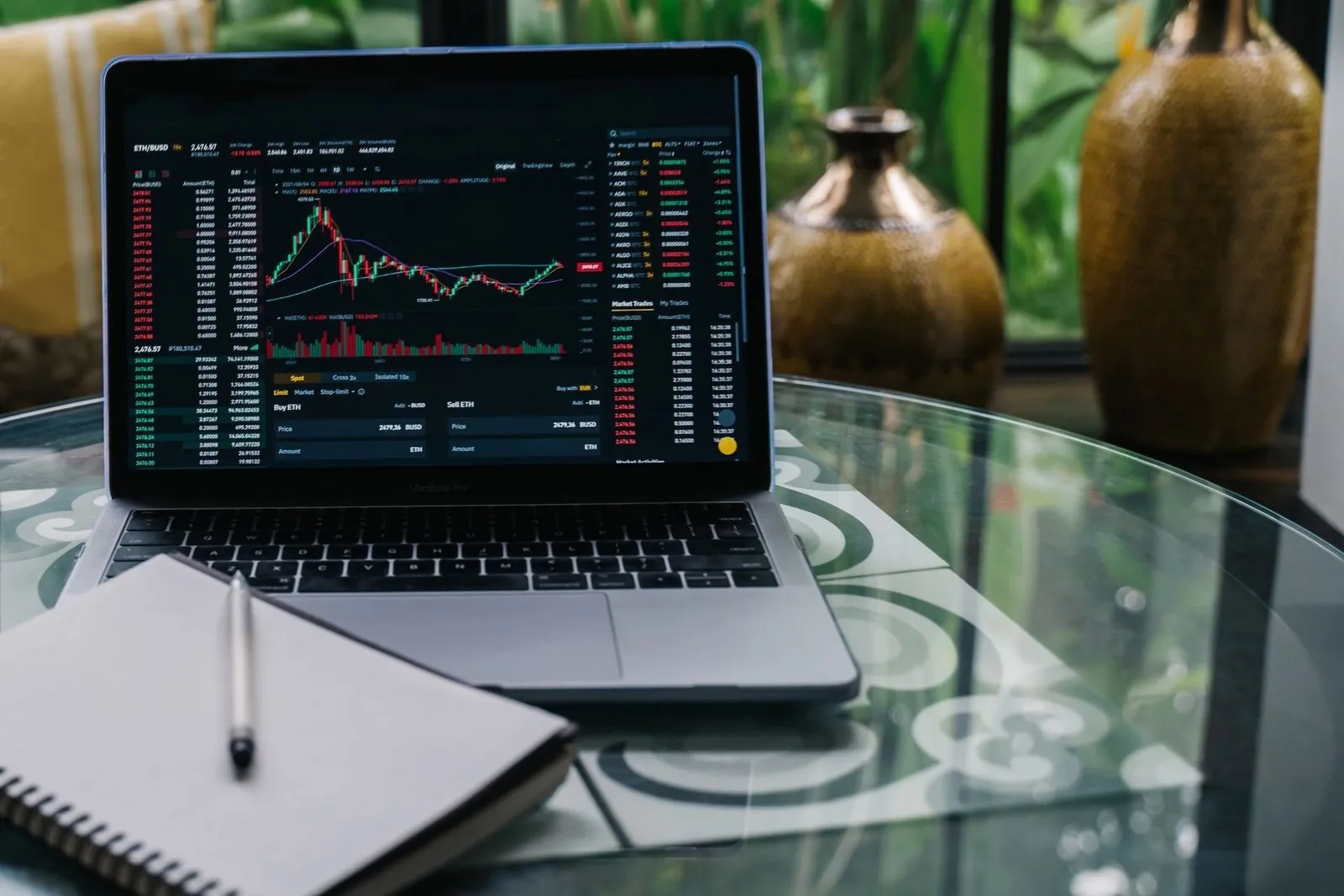 Laptop showing a crypto trading terminal on a glass table