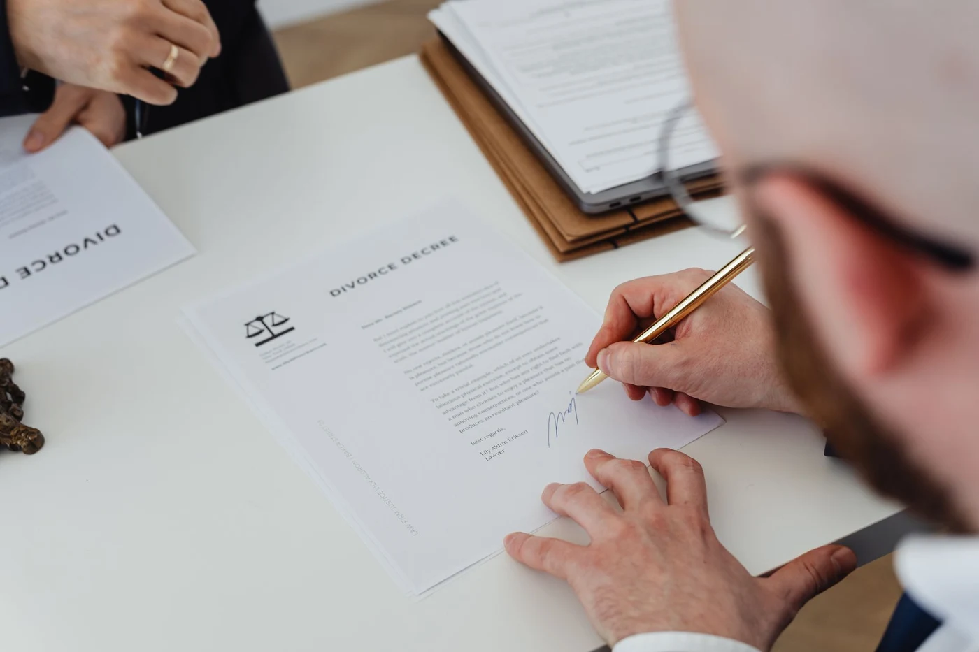 Close-up of a hand signing a printed employment contract at a desk