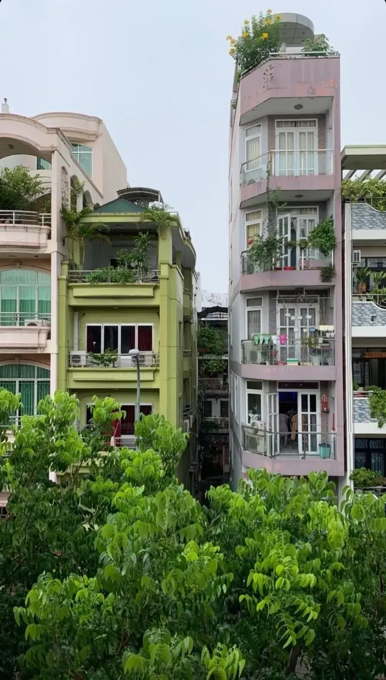 Multi-story apartment building with balcony gardens on a residential street
