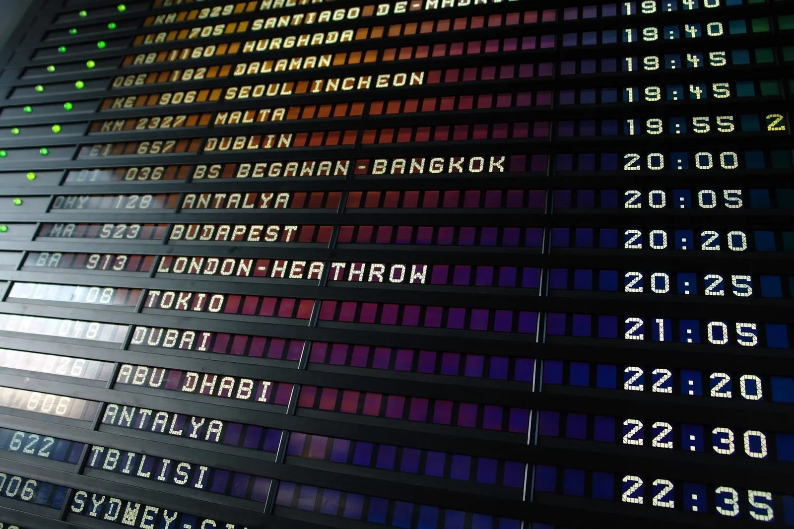 International departures board showing flight times to multiple hub cities
