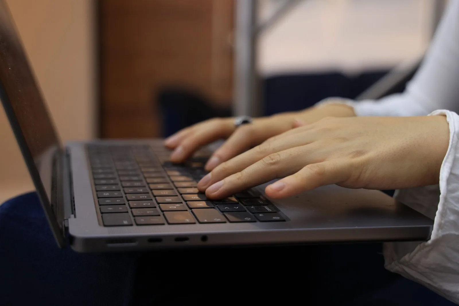 Close-up of hands typing on a laptop keyboard