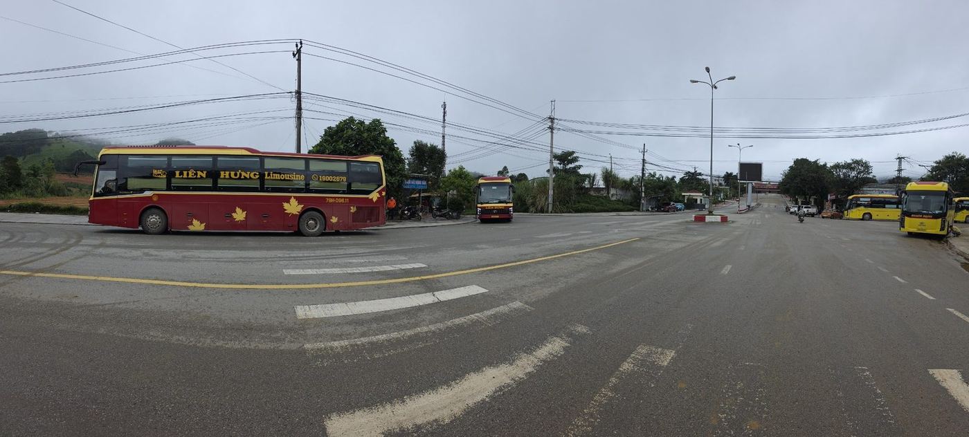 Another wide view of the same border crossing area with buses lined up near the checkpoint