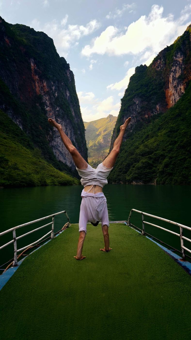 A boat with tourists doing acrobatics in the emerald-green Nho Que canyon in northern Vietnam