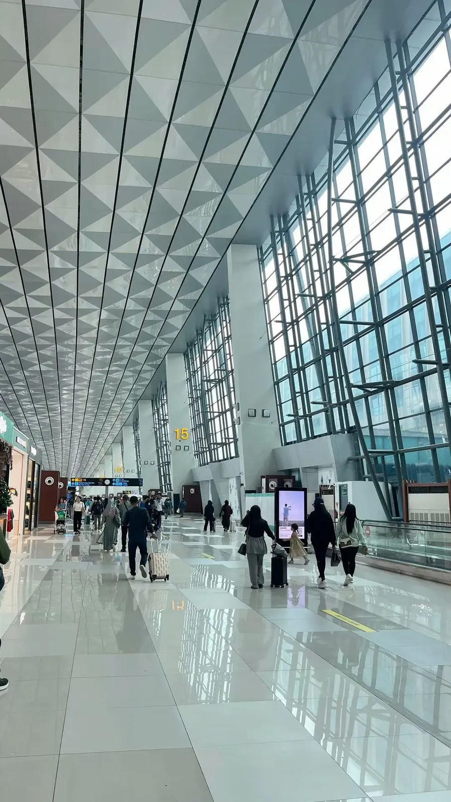 Travelers walking through a modern airport terminal corridor